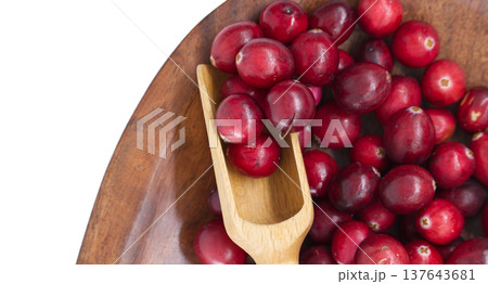 Fresh cranberries in a wooden bowl with a small wooden scoop 137643681