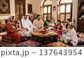 Family in traditional Arabian dress sharing festive meal indoors during celebration in luxurious home. Family, meal, tradition, celebration, home, Ramadan, Middle East. 137643954