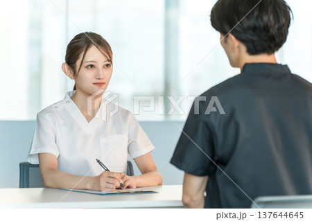カルテを見ながらカウンセリング,問診,検診,相談をする看護師の女性 カルテを見ながらカウンセリング,問診,検診,相談をする看護師の女性 137644645