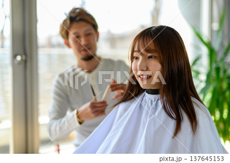 美容師が女性の髪をカット 137645153