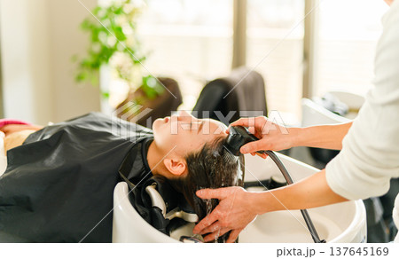 美容師が客の髪を洗う 137645169
