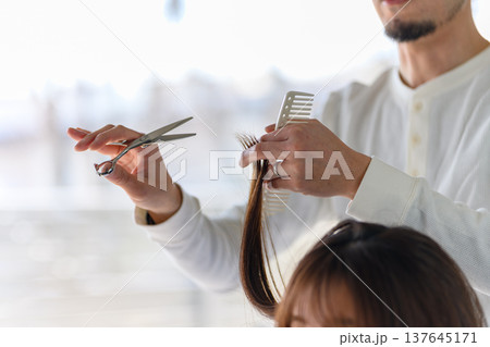 美容師が毛束を手に取りカットする 137645171