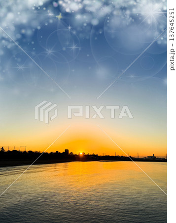 水面に反射する夕日の風景 オレンジ色の空と静かな海 137645251