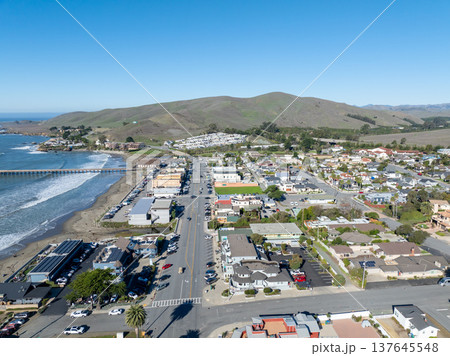 Aerial view of Cayucos, California USA, Pier, Ocean Ave and Shoreline Beach with Green Hills in San Luis Obispo County Aerial view of Cayucos, California USA, Pier, Ocean Ave and Shoreline Beach with Green Hills in San Luis Obispo County 137645548