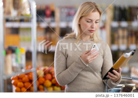 Young woman scanning qr code for spaghetti Young woman scanning qr code for spaghetti 137646001