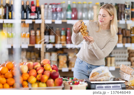 Young woman choosing grapes in grocery store Young woman choosing grapes in grocery store 137646049