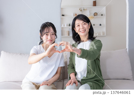 カメラ目線でハートマークを作る母と娘 137646061