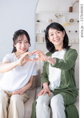 カメラ目線でハートマークを作る母と娘 137646063