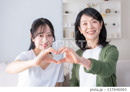 カメラ目線でハートマークを作る母と娘 137646065