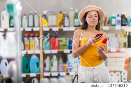Girl buyer scans qr code on sunblock cream label 137646210