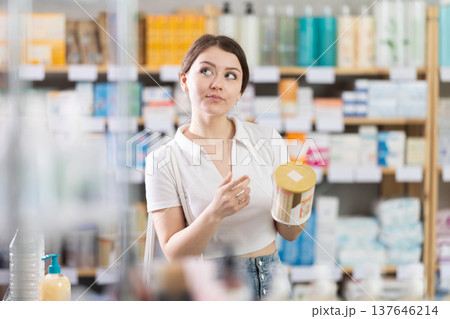 Young woman choosing baby formula in pharmacy 137646214