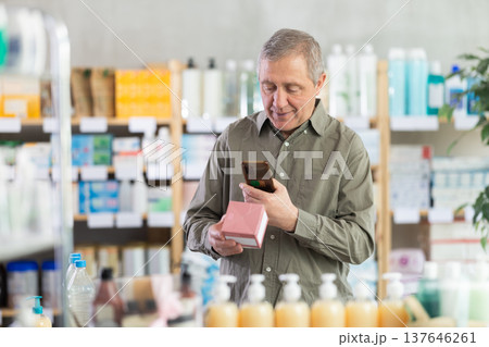 man scans a package of pills 137646261