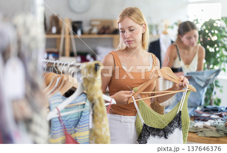 Young woman choosing clothes for the summer in the store Young woman choosing clothes for the summer in the store 137646376