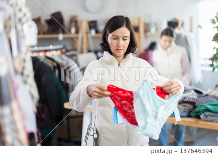 Woman looks at products in store and selects panties. Family shopping 137646394