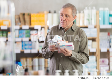 Elderly man with several packs of pills Elderly man with several packs of pills 137646396