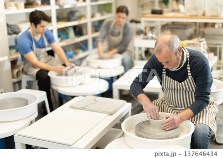 Eldery man shaping pottery on wheel in ceramics studio 137646434