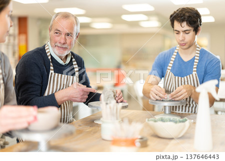 Young woman and man and elderly man crafting ceramics Young woman and man and elderly man crafting ceramics 137646443