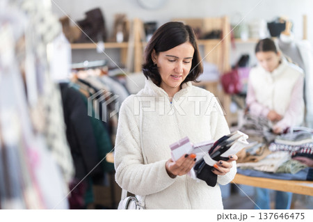 Adult woman chooses socks in clothing store Adult woman chooses socks in clothing store 137646475