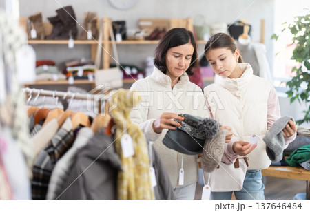 Adult woman and teenage girl choose hat 137646484