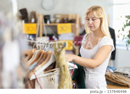 Fashionista girl near showcase examine goods, buying something clothing for summer. Fashionista girl near showcase examine goods, buying something clothing for summer. 137646496