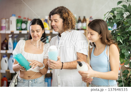 Teenage girl with parents choosing shower gel in personal care store 137646535