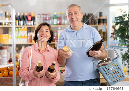 Senior couple hold bottle and choose consider alcohol beer in store 137646614