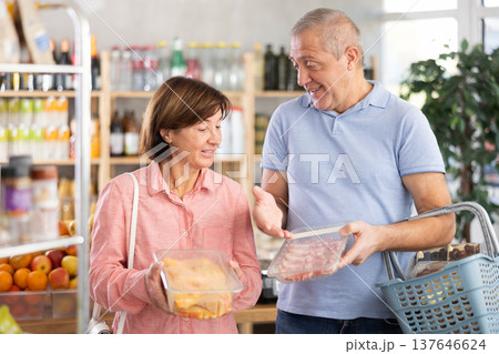 Couple elderly man and woman choosing chicken and pork Couple elderly man and woman choosing chicken and pork 137646624