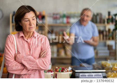 Family quarrel between elderly husband and wife in grocery supermarket. Husband screams at her wife Family quarrel between elderly husband and wife in grocery supermarket. Husband screams at her wife 137646632