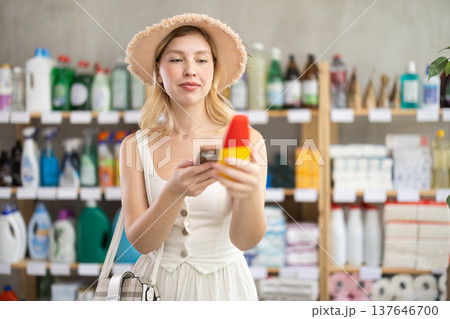 customer scans a package with a repellent on her phone 137646700