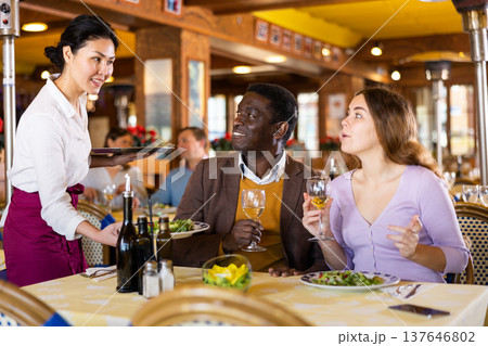 Asian waitress brought tray with restaurant guests Asian waitress brought tray with restaurant guests 137646802