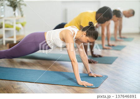 Young woman doing pilates in group in studio Young woman doing pilates in group in studio 137646891