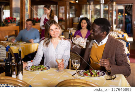 Man and woman chatting while having dinner in restaurant 137646895