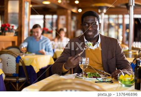 African-american man eating in restaurant African-american man eating in restaurant 137646896