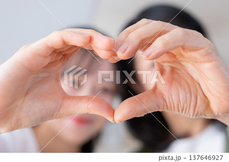 手でハートマークをつくる母と娘 137646927