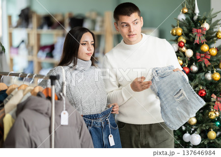 couple chooses jeans instead in a clothing store 137646984