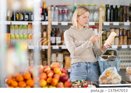 Young woman scanning qr code for mayonnaise Young woman scanning qr code for mayonnaise 137647053