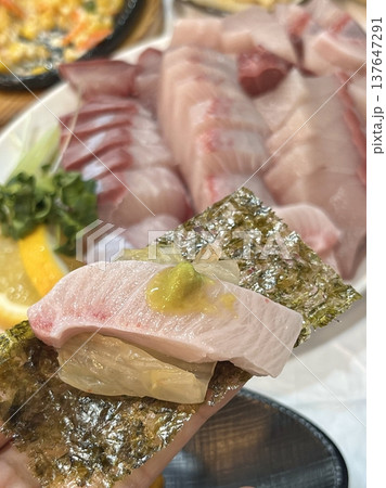 Fresh and delicate sashimi slices, beautifully presented with vibrant colors and perfect cuts. This traditional Japanese delicacy highlights the pure flavors of premium seafood. 137647291