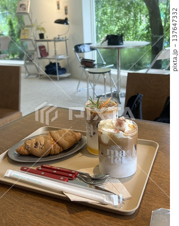 A delightful assortment of desserts displayed in a cozy cafe setting, featuring cakes, pastries, and sweet treats on elegant plates, creating a warm and inviting atmosphere. A delightful assortment of desserts displayed in a cozy cafe setting, featuring cakes, pastries, and sweet treats on elegant plates, creating a warm and inviting atmosphere. 137647332