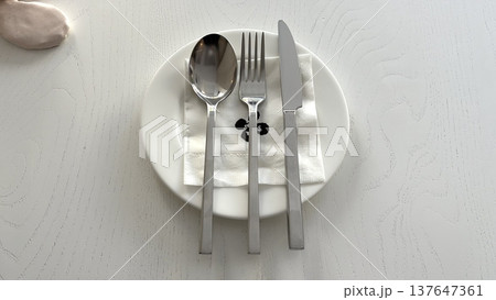 A sleek cutlery set featuring stainless steel forks, knives, and spoons with a polished finish. Designed for elegance and durability, perfect for casual dining or formal occasions. 137647361