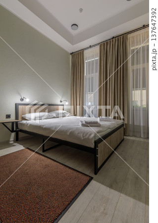 Modern Minimalist Hotel Bedroom with Double Bed and Warm Lighting 137647392