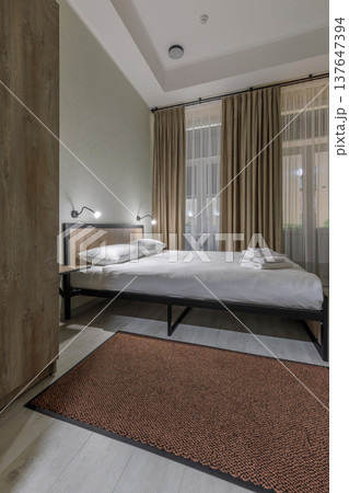 Compact Hotel Bedroom Interior with Double Bed and Hardwood Floor 137647394
