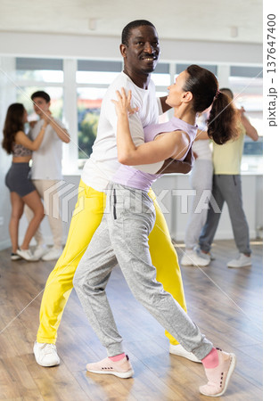 African American practicing bachata with brunette in dance class 137647400