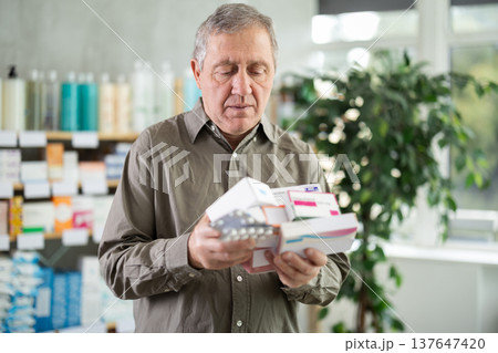 Elderly man with several packs of pills 137647420