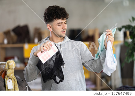 Young guy choosing women's panties in clothing store 137647499
