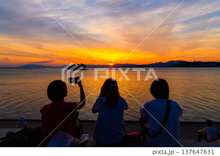 黄金色に輝く宍道湖の夕景、人物の後ろ姿が旅情感を演出する高画質素材 黄金色に輝く宍道湖の夕景、人物の後ろ姿が旅情感を演出する高画質素材 137647631