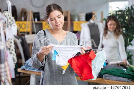 Cheerful young girl buyer choosing comfort panties in clothing store 137647651