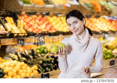 Young woman choosing apples in vegetable shop 137647658