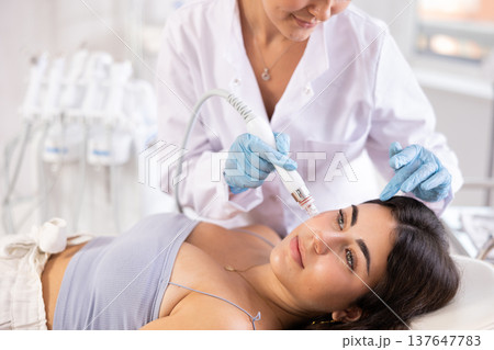 Beauty procedure to brunette girl (skin cleaning) 137647783