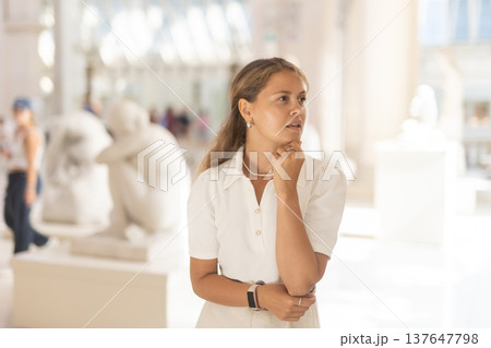 Woman with sheet piece of paper in hands view sculpture in museum hall Woman with sheet piece of paper in hands view sculpture in museum hall 137647798