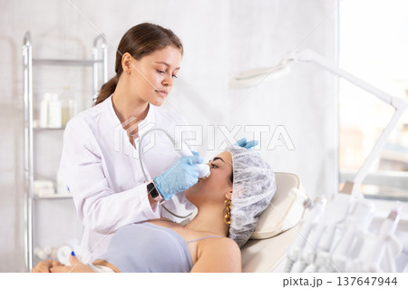 European doctor making Beauty procedure to brunette girl (vabration import) European doctor making Beauty procedure to brunette girl (vabration import) 137647944